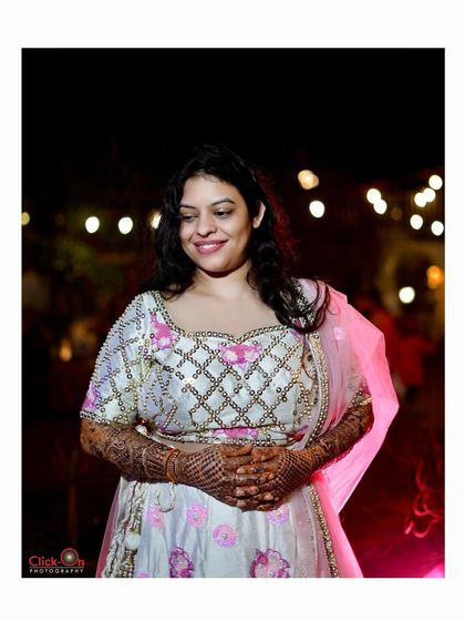 A lovely candid shot of a bride at her Mehndi function, with beautiful bokeh from the background lights.