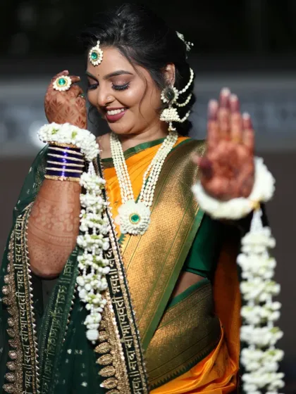 A playful and joyous shot. The bride shows off her floral hathphool and kalire, which add a lovely, delicate movement to her look.