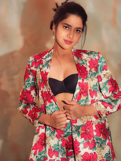 A confident and bold portrait of Karunya. The makeup is clean and modern, with a focus on her expressive eyes and a bright lip.