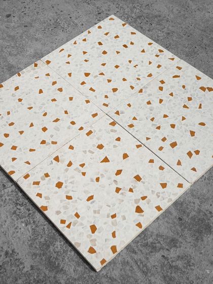 Four leather-finish Venetian terrazzo tiles laid together, showing the warm, earthy pattern created by the Jaisalmer stone chips.