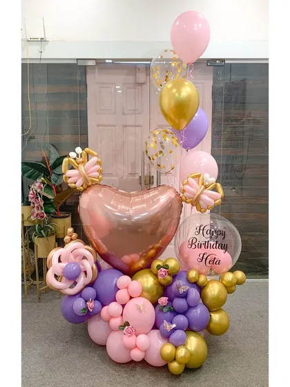 Butterfly beauty and balloon magic come together in this pretty bouquet. A mix of pink, purple, and gold balloons is accented with sculpted butterflies and a personalized message for Hela's birthday.