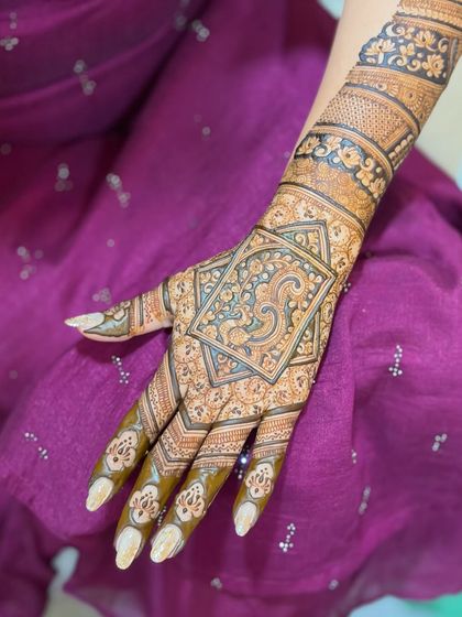 One hand from a full bridal set, showing the intricate detail work on the palm and the beautiful bands on the arm.