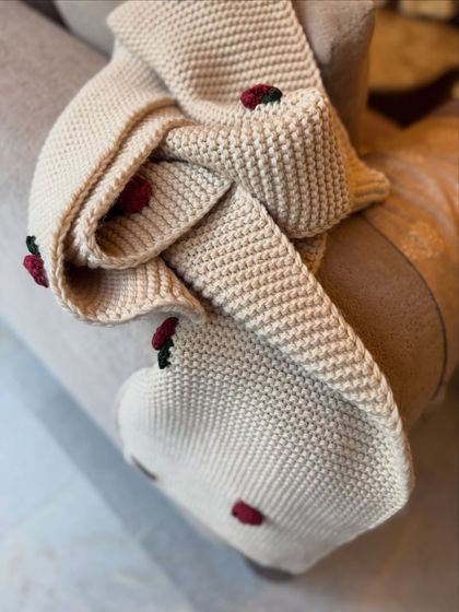 A different angle of our cream muffler with red rose details. This shot highlights the texture of the stitch and the lovely 3D effect of the roses.
