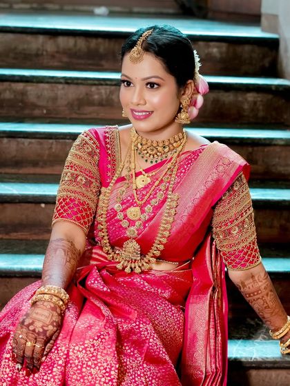 A beautiful portrait of a classic South Indian bride. Her smile radiates joy, and the makeup enhances her features with a timeless elegance.