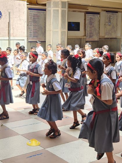 Young students in school uniforms participate in a coordinated running drill. We make physical education fun and accessible, even within the constraints of a school courtyard.