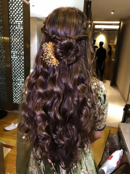 A back view of the reception guest's hairstyle, showing a braided half-updo with a gold accessory.