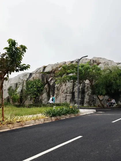 In this project, we chose to preserve and feature a magnificent natural rock outcropping, designing the community road to curve around it. This demonstrates our core belief in integrating the built environment with the existing landscape, making nature the centerpiece.