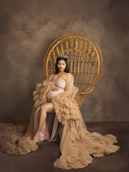 Every mother is a queen, and in my studio, we make that a reality. This portrait, with the regal peacock chair and a flowing tulle gown, is all about celebrating your strength and grace in a timeless, elegant style.