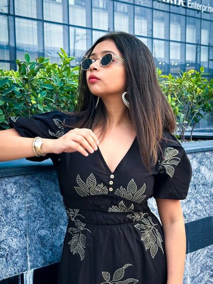 A close-up portrait in the black dress, showing off the v-neckline, puff sleeves, and my cool, round sunglasses.