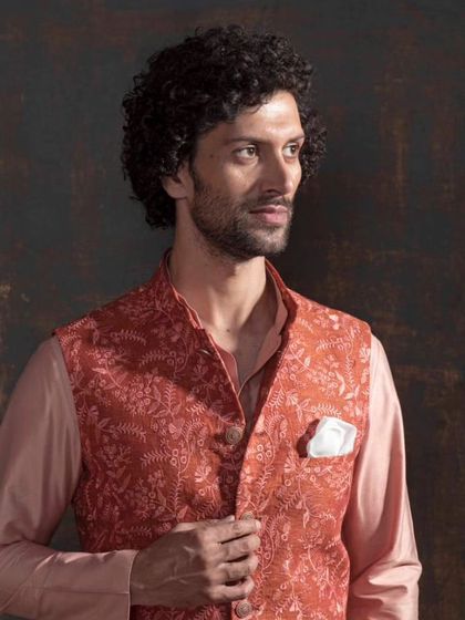 Elevate your elegance with this stunning traditional ensemble. This peach Nehru jacket with a matching kurta features exquisite craftsmanship and a timeless design that speaks volumes.