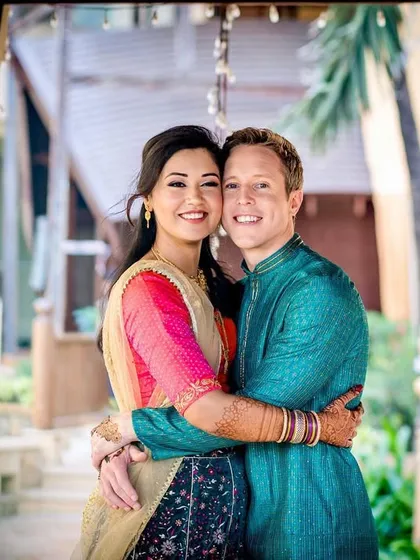 A classic, smiling portrait of a couple embracing. Their direct gaze at the camera and warm smiles make this a timeless and heartwarming image.