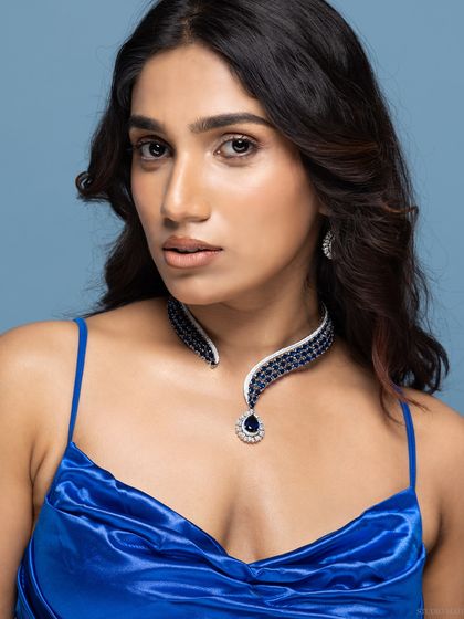 A beauty portrait showcasing a stunning sapphire and diamond choker necklace. The royal blue dress complements the jewellery perfectly.