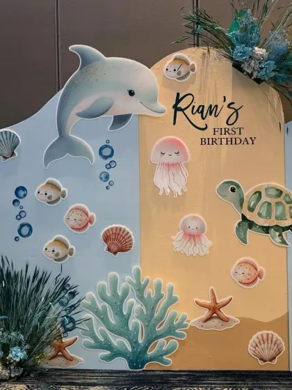 A clean, high-quality shot of the custom backdrop for Rian's first birthday, showing the charming illustrated sea animals.