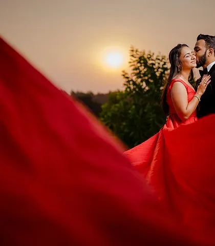 A classic sunset embrace, elevated by a dramatic red gown. We work with light and fabric to create breathtakingly romantic images that feel like a scene from a movie.