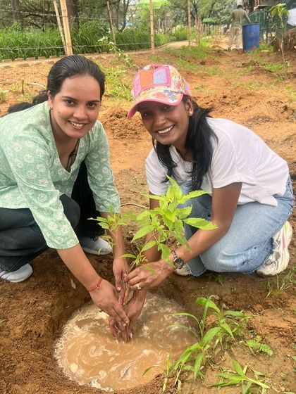 Two smiling volunteers from Infoglen pose after planting a sapling. Their joy and sense of accomplishment are what make these community drives so special.