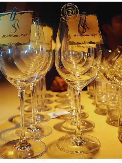 A row of wine glasses, each with a custom tag featuring the couple's initials and wedding hashtag, #SidKiSawaRiya. It's all about celebrating your union.