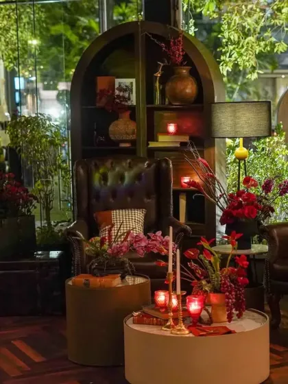 This cozy nook was styled to feel like a classic study, with leather wingback chairs, an arched bookshelf filled with curios, and warm, intimate lighting from vintage-style lamps.