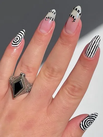 A bold, graphic black and white manicure with hypnotic swirls and stripes for a high-impact look.