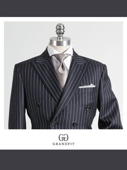 The double-breasted pinstripe suit is an icon of sartorial power. Our meticulous tailoring is evident in the balanced peak lapels and structured shoulders, creating a garment that is both classic and contemporary.