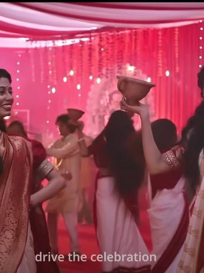 Dancers at the Durga Puja celebration, styled in traditional white and red Bengali sarees, creating a visually stunning and authentic scene.