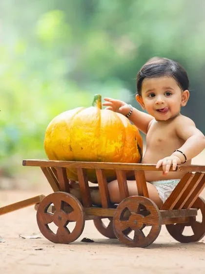 This joyful portrait captures a playful moment during a harvest-themed sitter session. The simple setup keeps all the attention on his adorable face.