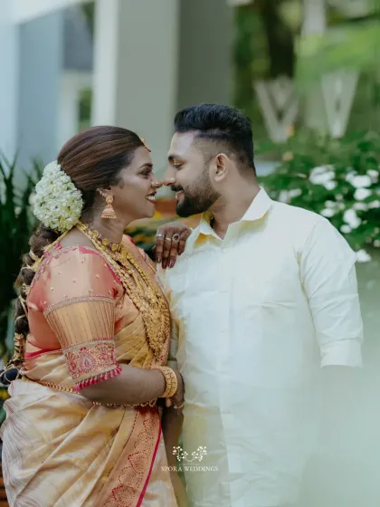 A candid moment of love and laughter between the bride and groom, her jasmine-adorned hair and his simple elegance defining the beauty of a Kerala wedding.
