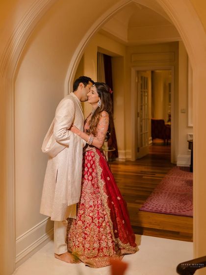 A gentle kiss in a quiet hallway. This photo captures a moment of stolen intimacy away from the wedding festivities.
