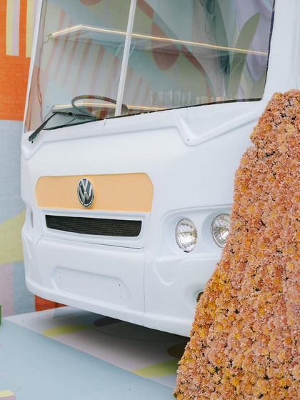 A close-up of the custom-fabricated VW bus bar, painted white with peach accents and surrounded by floral arrangements.