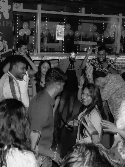 A black and white shot of the party, capturing the timeless joy of dancing with friends.