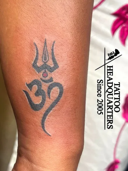 A bold Om and Trishul tattoo, combining two of the most powerful symbols in Hinduism into a single, impactful design.