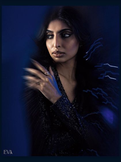 A close-up portrait from our motion blur series. The artistic blur around the model's hand and the dramatic blue lighting create a mysterious and high-fashion mood.