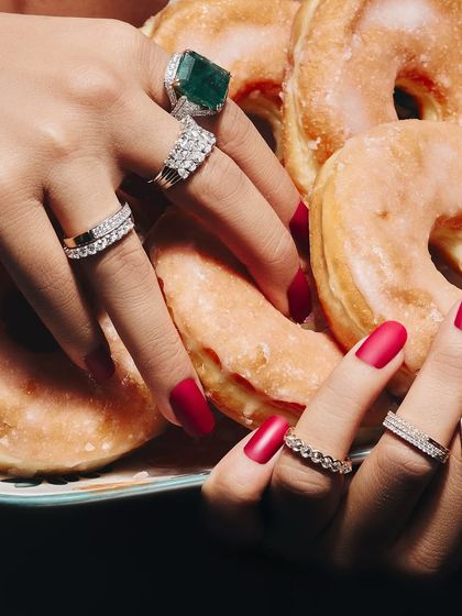 How many rings are too many? I believe it's never enough. This image shows a delicious stack of diamond eternity bands and a statement emerald ring, proving that more is more.