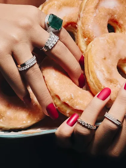 How many rings are too many? I believe it's never enough. This image shows a delicious stack of diamond eternity bands and a statement emerald ring, proving that more is more.
