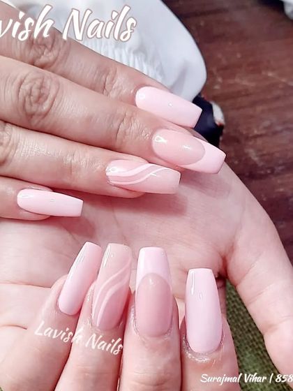 A subtle and elegant design with solid pink nails and a delicate white swirl accent.
