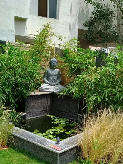 A key feature of this garden is the granite water feature with a Buddha statue, surrounded by bamboo. This creates a peaceful focal point in the yard.
