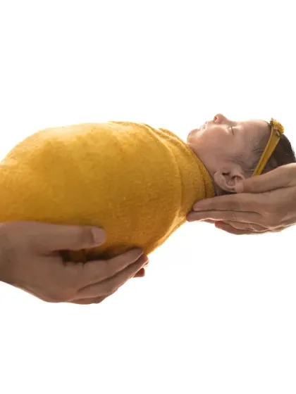 A simple, symbolic shot of parents' hands holding their newborn. This highlights just how small and protected your baby is in your care.