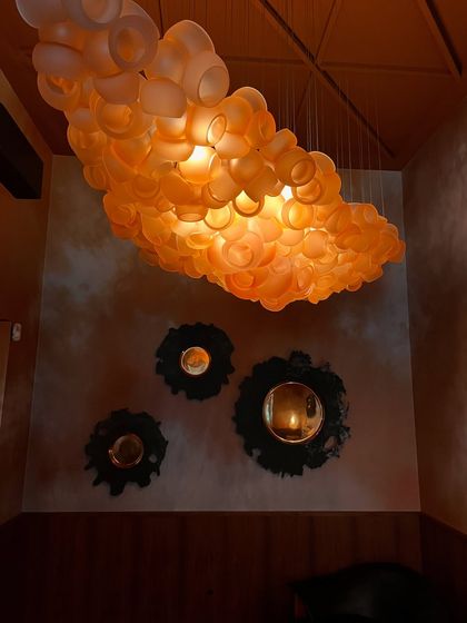 A low-angle shot of the Bocci 100 series chandelier, emphasizing its dense, clustered form and the warm, inviting light it emits.