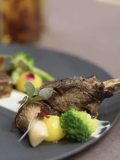 A close-up of our grilled lamb, showcasing the beautiful char marks and the fresh vegetables that accompany it.