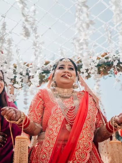 The bride's grand entrance under a phoolon ki chadar, a classic and emotional moment from a North Indian wedding.