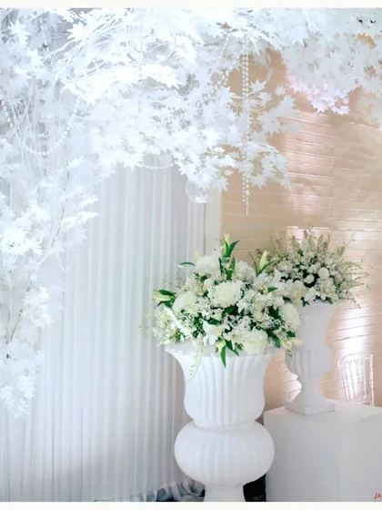 A corner of pure white elegance. I used white floral arrangements in classic urns against a backdrop of white drapes and foliage to create a timeless and sophisticated look.