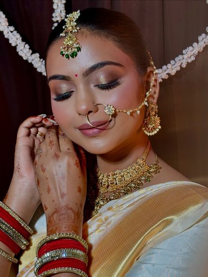 A candid moment with my bride Divya as she gets ready. This shot captures the soft, shimmery eye makeup and the intricate details of her bridal jewellery.