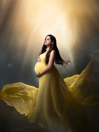 An underwater dream. This creative, digitally enhanced portrait depicts the mother-to-be in a flowing yellow gown, bathed in heavenly light as if floating in water.