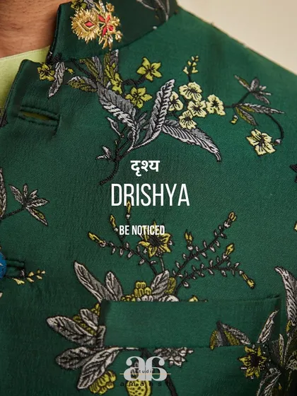 A detailed close-up of the emerald green bundi's fabric. The exquisite embroidery and custom buttons showcase the artistry involved in creating our garments.