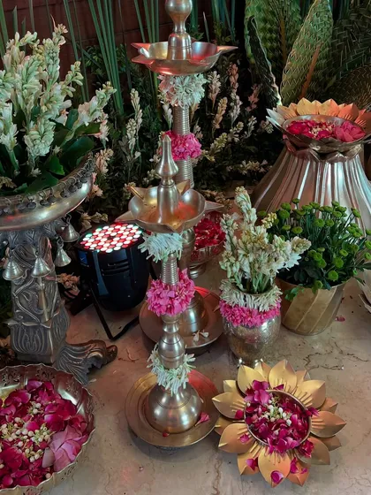 A detailed shot of the traditional decor corner, filled with brass elements, tuberoses, and rose petals, creating a fragrant and festive atmosphere.