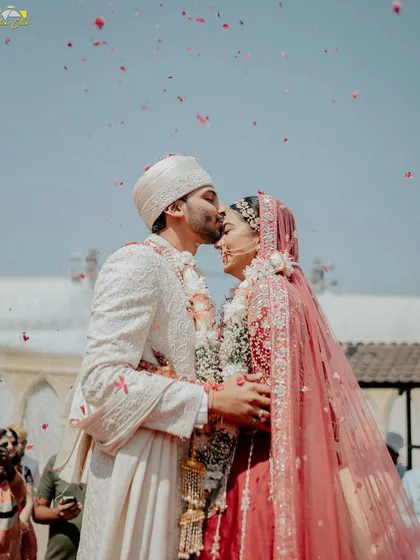Sometimes, the most powerful moments are the quietest. This forehead kiss during the wedding ceremony is a classic shot, but it’s the genuine emotion and the shower of petals that make it special. It showcases our focus on capturing intimate, heartfelt connections amidst the grandeur of the wedding day.