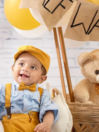 Up, up, and away! This little pilot is ready for an adventure in our hot air balloon setup, a perfect theme for celebrating a half-birthday milestone.