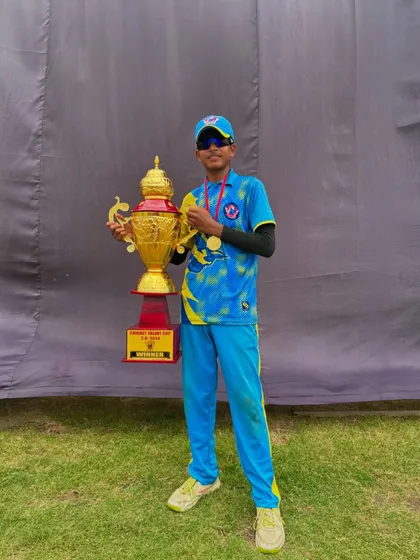 A young player proudly holding the trophy he helped win.