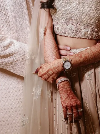 A close-up on the details. The bride's intricate henna and the way the couple holds hands tells a story of its own.