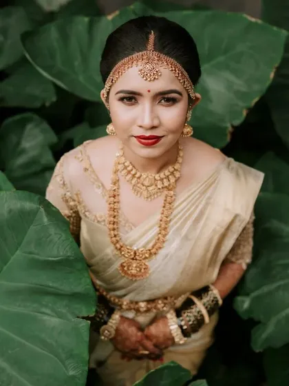 A portrait of a South Indian bride in her element. We used the lush green foliage to frame her elegance, highlighting the rich texture of her silk saree and traditional gold jewelry.