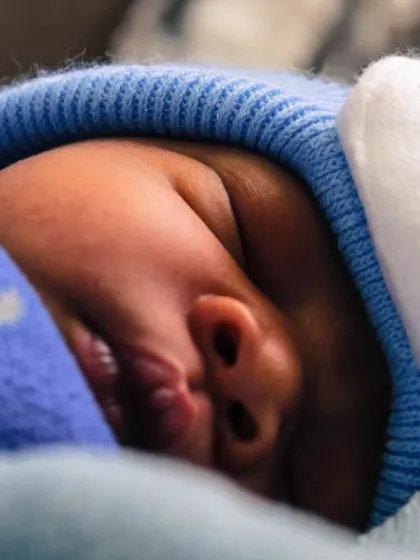 A close-up of a newborn snug and warm in a cute blue hat. I love capturing these sleepy, peaceful moments where all the focus is on their tiny, perfect features.